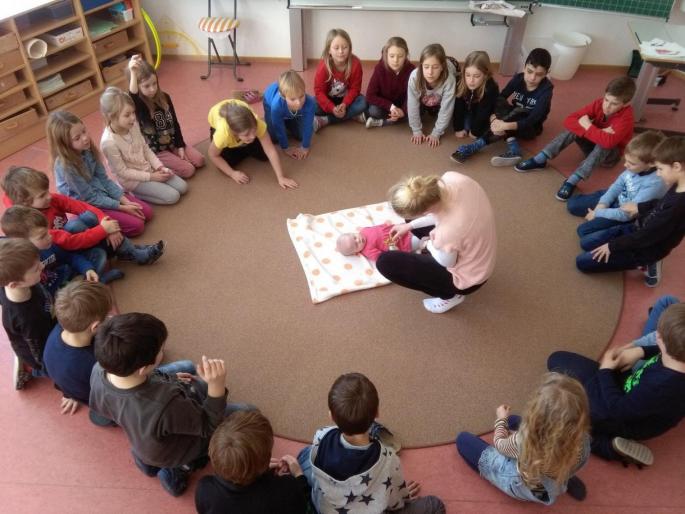 Kinder der 2. und 3. Schulstufe beim Babywatching mit Angelika und Baby Lisa