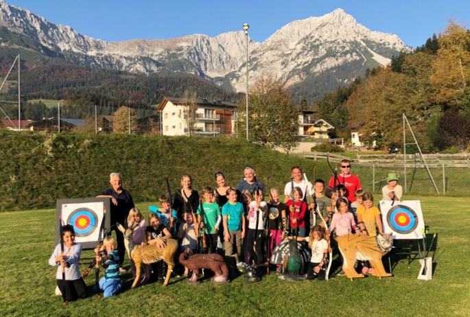 Multisportgruppe beim Bogenschießen am Sportplatz in Scheffau mit vielen Helfern und Lehrerin Verena Wieser