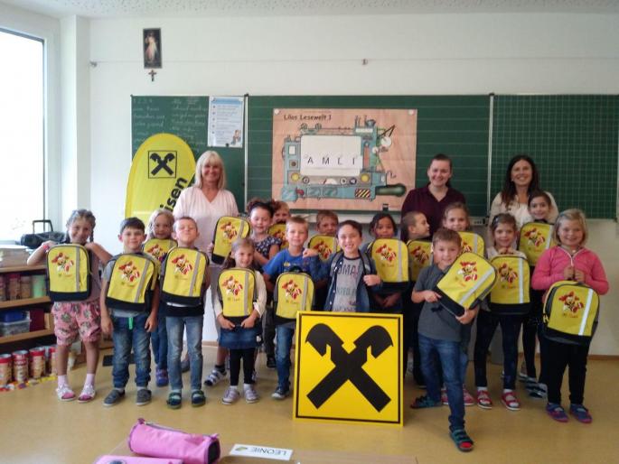 Kinder der ersten Stufe mit Rucksäcken der Raiffeisenbank